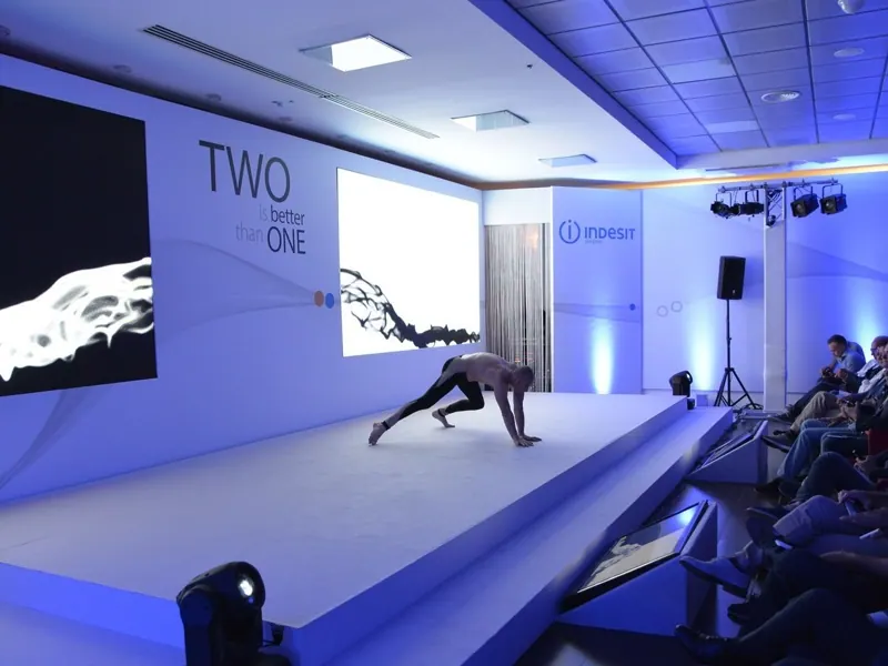 Palco bianco con LED wall e performer durante una convention