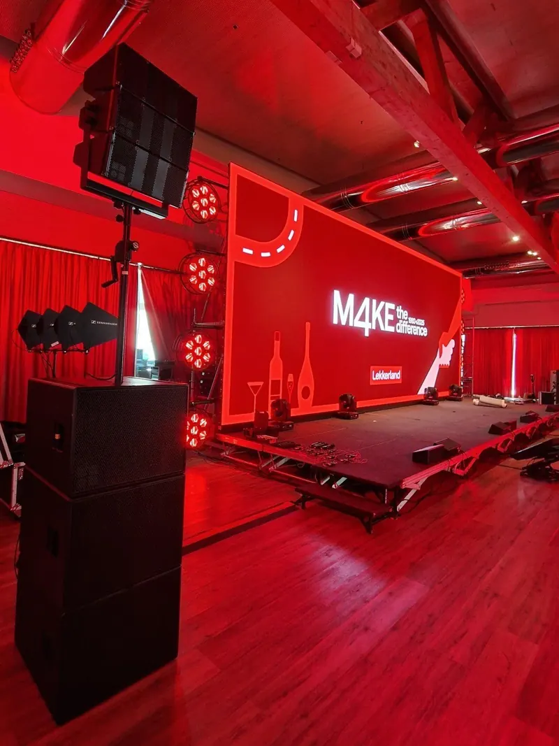 Palco illuminato di rosso con casse appese