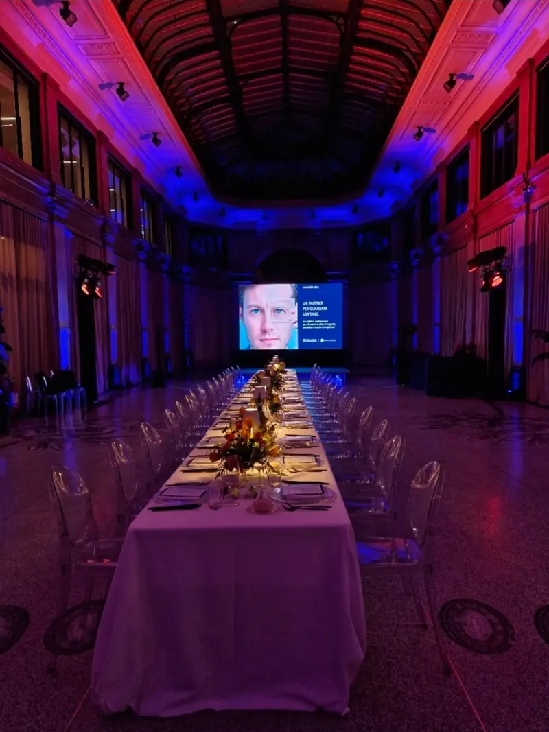 Cena di gala in Galleria Meravigli a Milano con luci blu e rosse e schermo LED