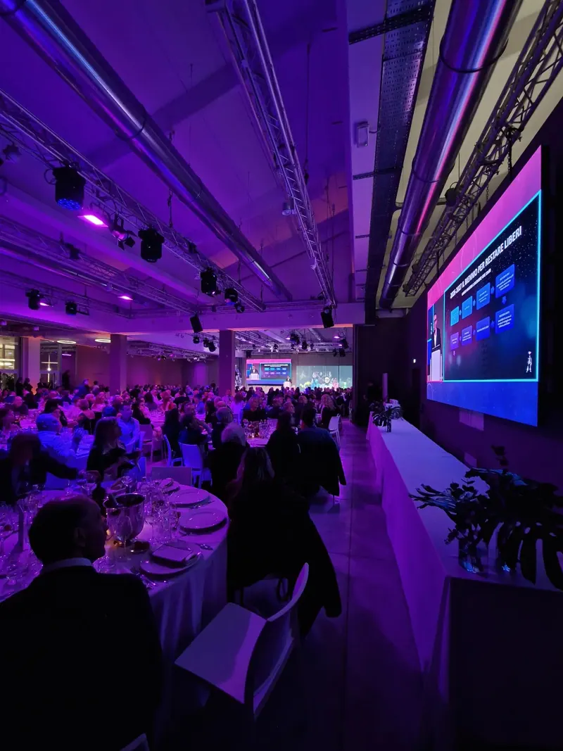 Cena con pubblico e schermo LED in una sala illuminata di viola