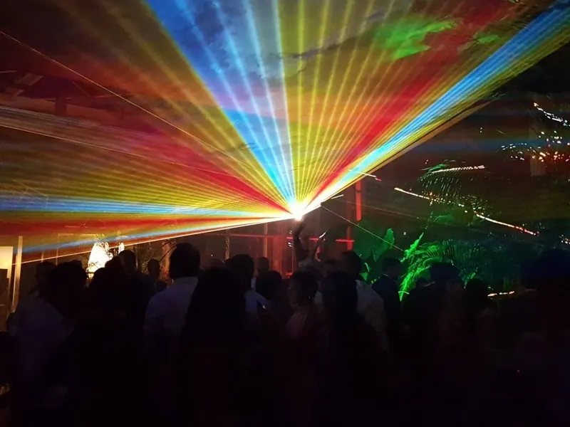 Laser show con raggi multicolore in un giardino