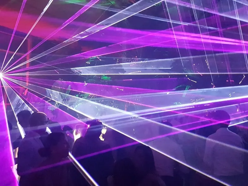 Laser show con fasci viola sopra il pubblico