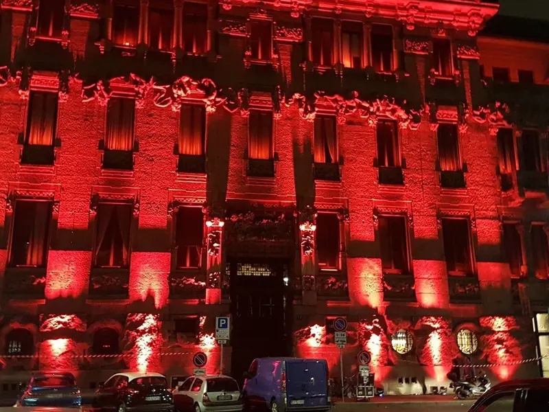 Facciata di un palazzo storico illuminata di rosso