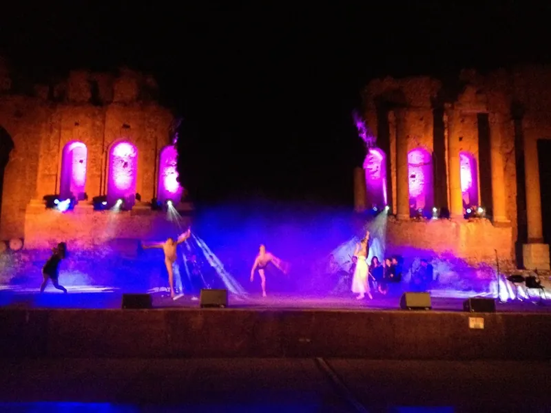 Spettacolo serale in un teatro antico con luci colorate