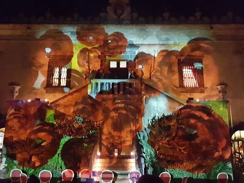 Videomapping con fiori proiettati sulla facciata di un palazzo storico