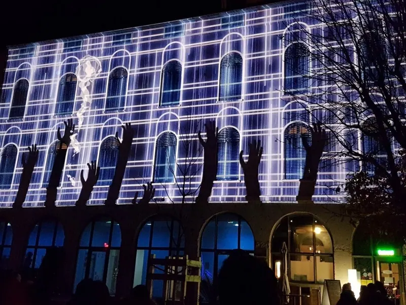 Videomapping con una griglia luminosa sulla facciata di un palazzo